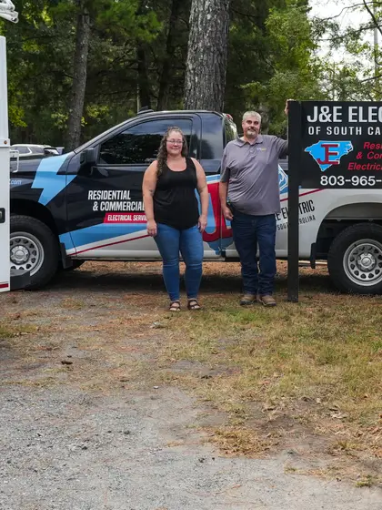 The J&E Electric team with the company vans