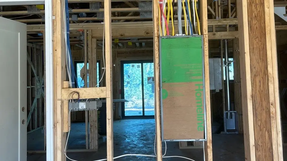 New electrical panel with circuit wiring installed between wall studs during a J&E Electric job