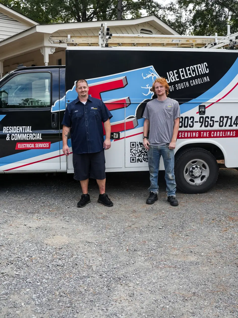 Two J&E Electric electricians standing beside a J&E Electric of South Carolina service truck.
